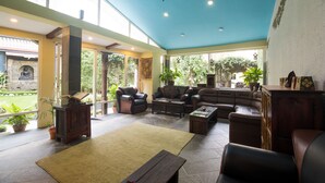 Un salón amplio con techo alto, ventanas grandes y vistas al jardín.