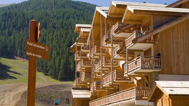 A wooden chalet with multiple balconies and a sign indicating 'Point information' and 'Jardin des neiges'. - Wifi, ski-in/ski-out & foot of the slopes, swimming pool, balcony, 40-50m², Les Orres (Les Orres)