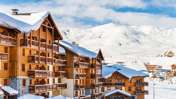 A wooden chalet-style hotel with multiple balconies and a ski slope in the background. - 100m from ski slopes, swimming pool, sauna, hammam, balcony, tv, ski locker, 32m², La Toussuire (Fontcouverte-la-Toussuire)