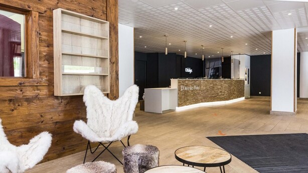 A modern interior with wooden walls, a reception desk, and a seating area with fluffy chairs. - Wifi, 100m from shops, swimming pool, parking, tv, ski locker, 32m², Saint Sorlin d'Arves (Saint-Sorlin-d'Arves)
