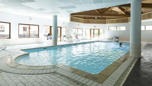 An indoor swimming pool with clear water, surrounded by lounge chairs and a tiled floor. - Wifi, 100m from shops, swimming pool, parking, tv, ski locker, 32m², Saint Sorlin d'Arves (Saint-Sorlin-d'Arves)