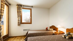 A bedroom with two beds, a window with curtains, a nightstand with a lamp, and a teddy bear. - 80m from ski slopes, swimming pool, terrace, balcony, tv, ski locker, 70m², Peisey-Vallandry (Peisey-Nancroix)