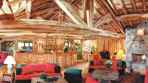 A log cabin interior with a stone fireplace, wooden furniture, and a high ceiling. - Fitness, swimming pool, balcony, tv, ski locker, 35m², Les Saisies (Les Saisies)
