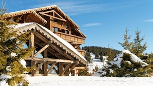 A wooden chalet with a balcony, surrounded by snow-covered trees and a clear sky. - Fitness, swimming pool, balcony, tv, ski locker, 35m², Les Saisies (Les Saisies)