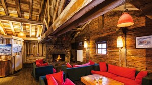 A rustic wooden interior with a stone fireplace, wooden furniture, and hanging lamps. - Fitness, swimming pool, balcony, tv, ski locker, 35m², Les Saisies (Les Saisies)