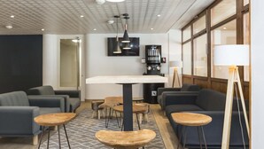 A modern lounge area with sofas, round tables, and a central coffee table. - Wifi, ski-in/ski-out & foot of the slopes, swimming pool, balcony, parking, tv, ski locker, 26m² (Saint-Sorlin-d'Arves)