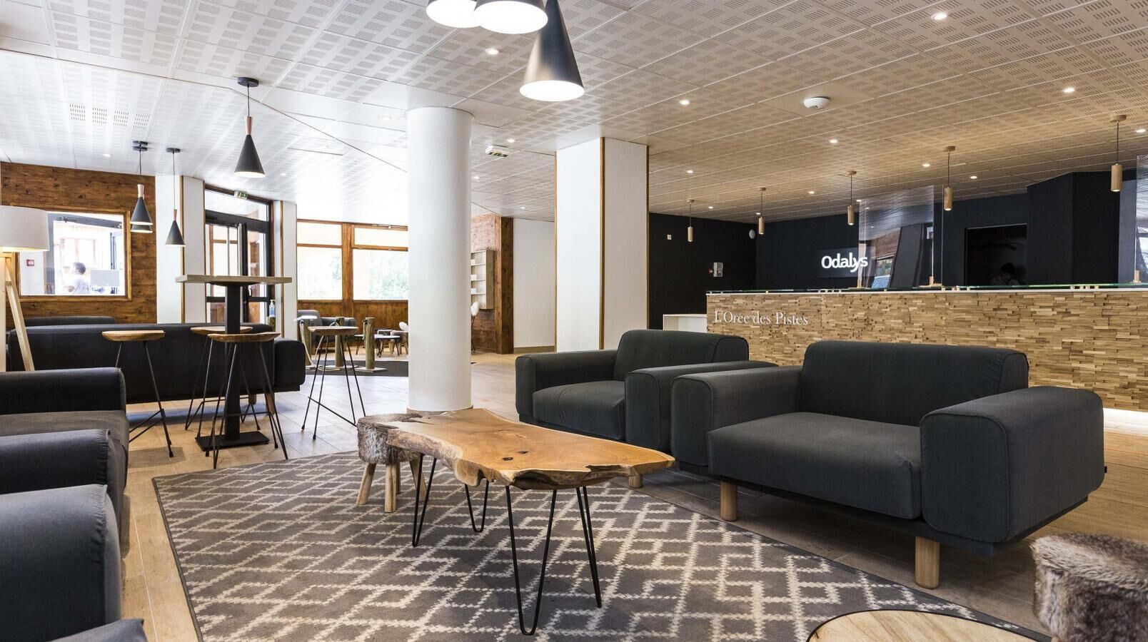 Zona d'estar moderna amb sofàs, una taula de café i una barra.