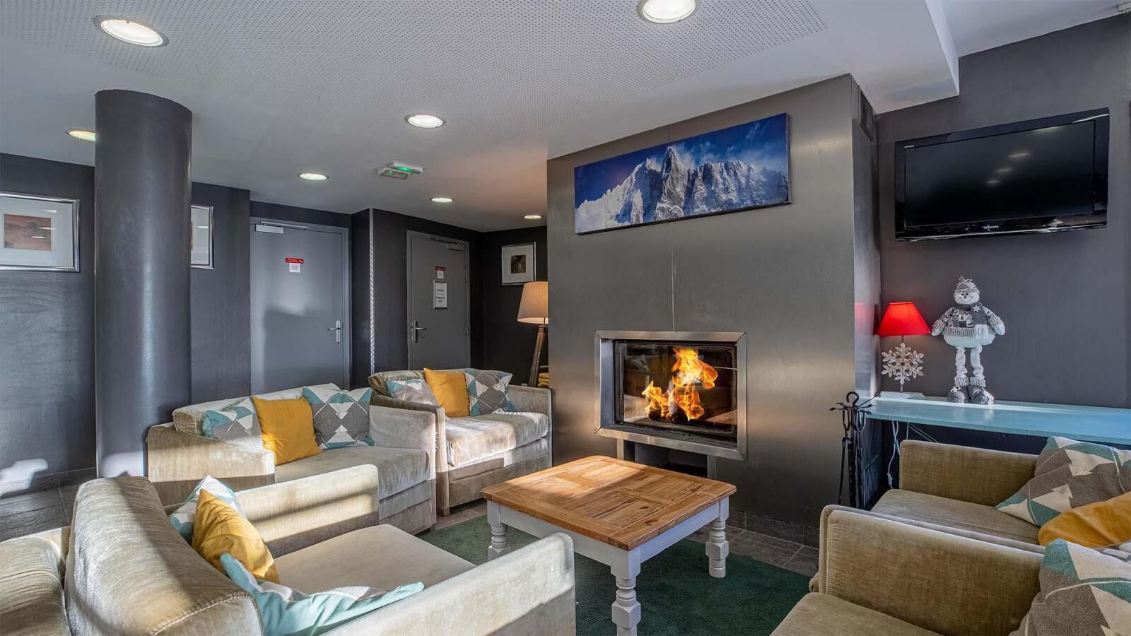 Een moderne lounge met banken, een open haard en een flatscreen televisie.