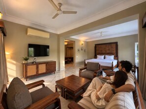 Une chambre d’hôtel avec un lit, une télévision, un canapé et une table basse.