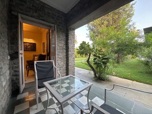 A room with a checkered floor, a glass table, a chair, and a doorway leading outside. - King’s Abode - Luxuria Ranakpur by Moustache (Desuri)