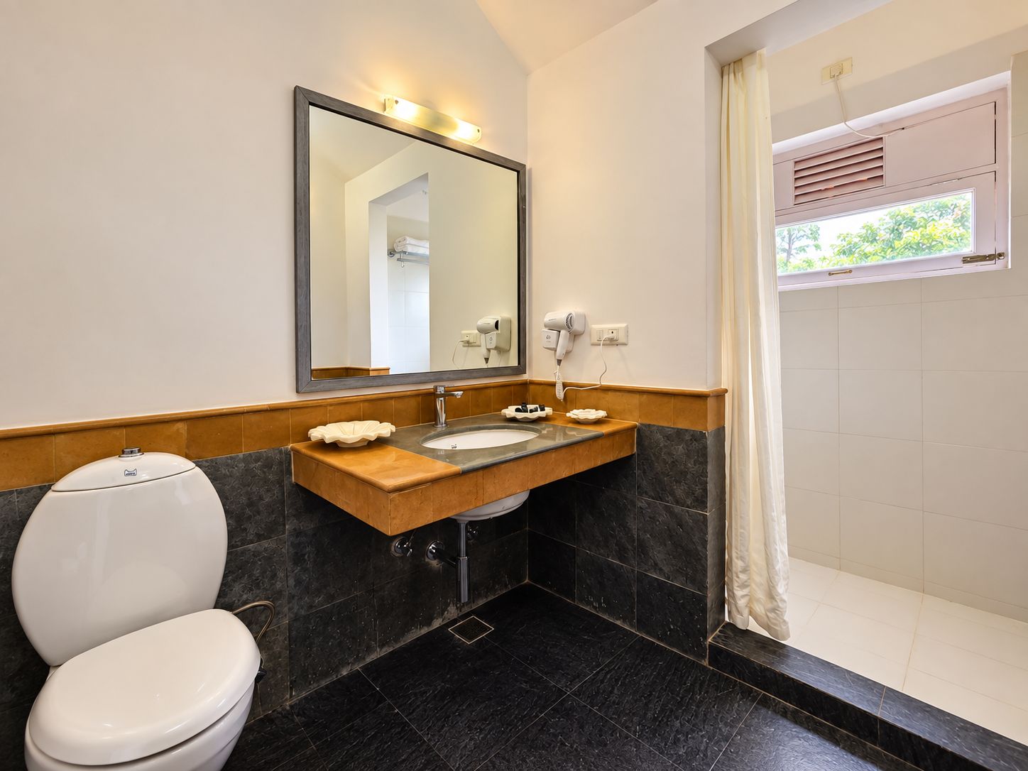 Un baño con inodoro, lavamanos y ducha.
