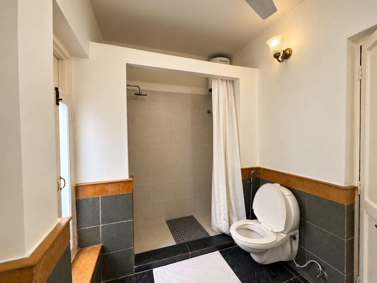 A bathroom with a shower, toilet, and a towel rack.