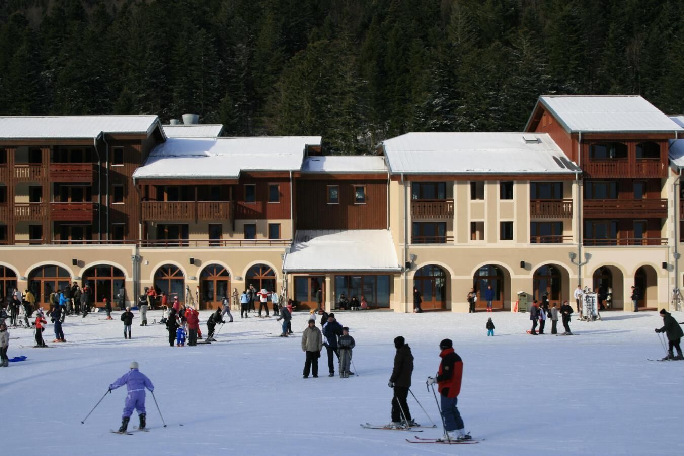 Une station de ski comprenant plusieurs bâtiments dotés de balcons et d’entrées en forme d’arc.