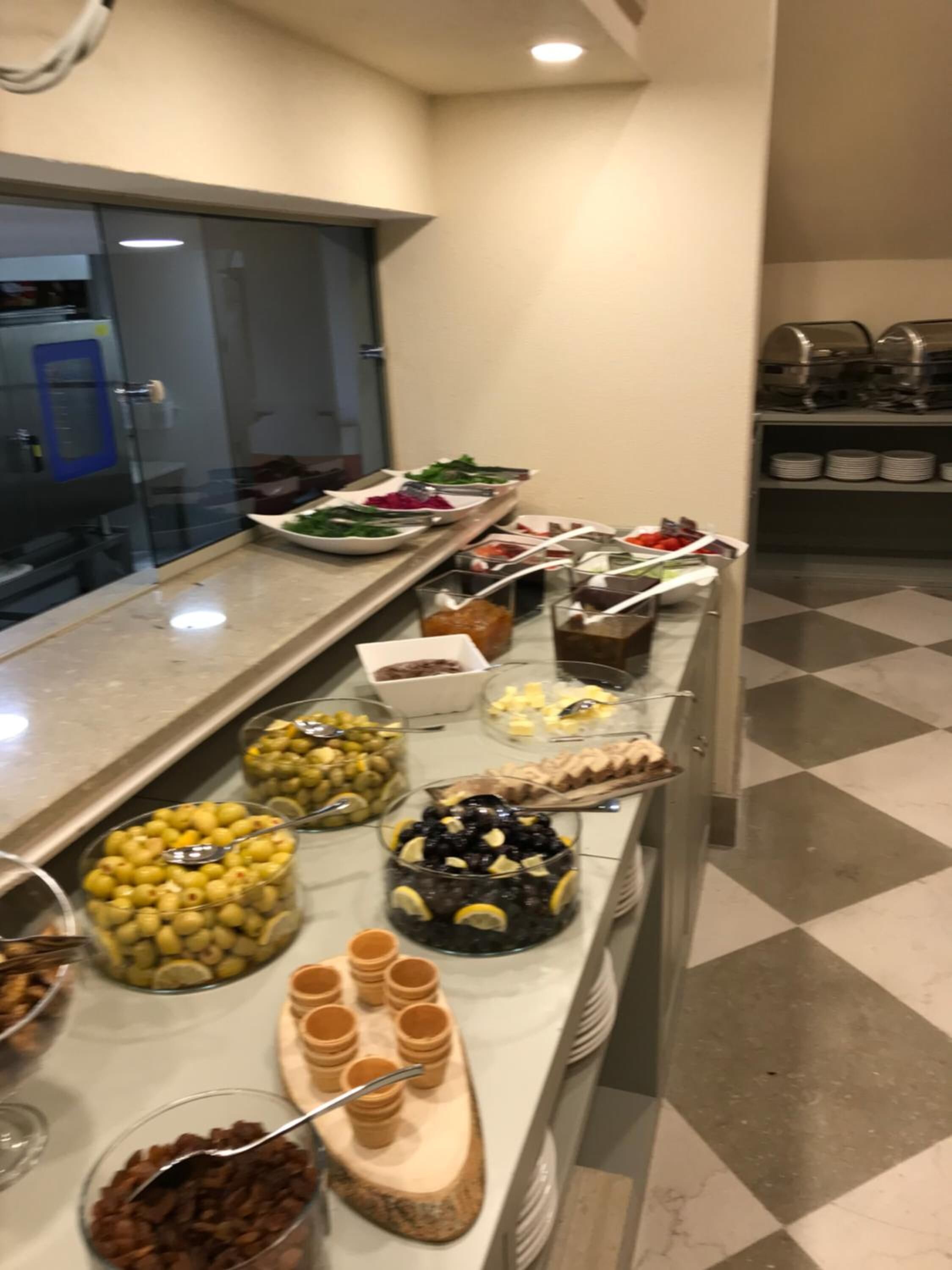 Een buffet met diverse soorten eten, waaronder olijven, kaas en andere hapjes.