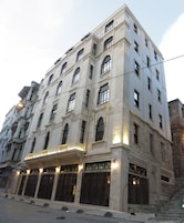 Un edificio de varios pisos con amplias ventanas y una entrada destacada.