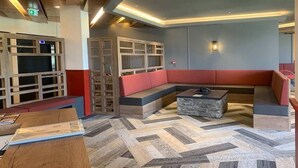 A modern lounge area with a herringbone-patterned floor, a red cushioned bench, and a wooden coffee table. - 300m from resort center, balcony, tv, ski locker, 16m², Val Thorens (Val Thorens)