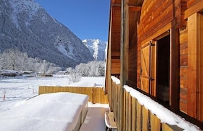 Cozy cabin nestled among snow-covered mountains, offering a peaceful retreat.