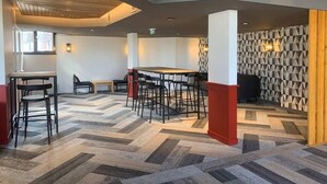 A modern interior with a herringbone patterned floor, a central table with chairs, and a geometric patterned wall. - 300m from resort center, tv, ski locker, 16m², Val Thorens (Val Thorens)