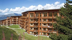 A multi-story hotel with balconies, set against a mountainous backdrop. - Fitness, swimming pool, sauna, hammam, terrace, balcony, tv, ski locker, 60-70m², Les Arcs (Les Arcs)