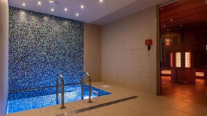 A spa area with a mosaic wall, a small pool, and a wooden structure with lights. - Fitness, swimming pool, sauna, hammam, terrace, balcony, tv, ski locker, 60-70m², Les Arcs (Les Arcs)