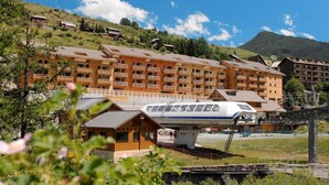 A hotel with multiple wooden buildings, a ski lift, and a train on tracks. - Fitness, swimming pool, tv, ski locker, 23m², Vars (Vars)