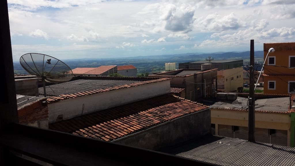 Una azotea con una antena parabólica, vistas a montañas lejanas y cielo despejado.