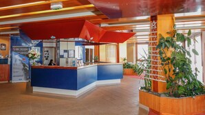 A reception area with a blue counter, a red awning, and a wooden plant display. - Ski-in/ski-out & foot of the slopes, tv, ski locker, 16m², Val Thorens (Val Thorens)