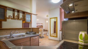 A modern kitchen with a stainless steel stove, a double sink, and wooden cabinetry. - Feel Belgrade Superior Apartment (Belgrade)