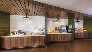 Een moderne keuken met houten kastjes, een witte betegelde spatwand en een ingebouwde koelkast.