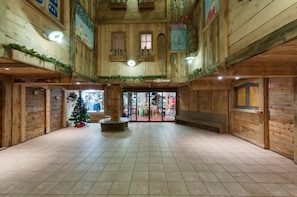 A spacious indoor area with wooden walls and tiled flooring, featuring a Christmas tree, benches, and a ski room sign. - Ski-in/ski-out & foot of the slopes, view mountain/ski slopes, balcony, tv, ski locker, 27m² (Val Thorens)
