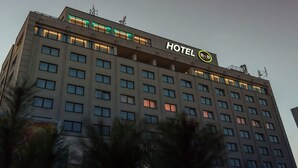 Un immeuble d’hôtel à plusieurs étages, dont la façade est ornée d’une grande enseigne indiquant « HÔTEL ».