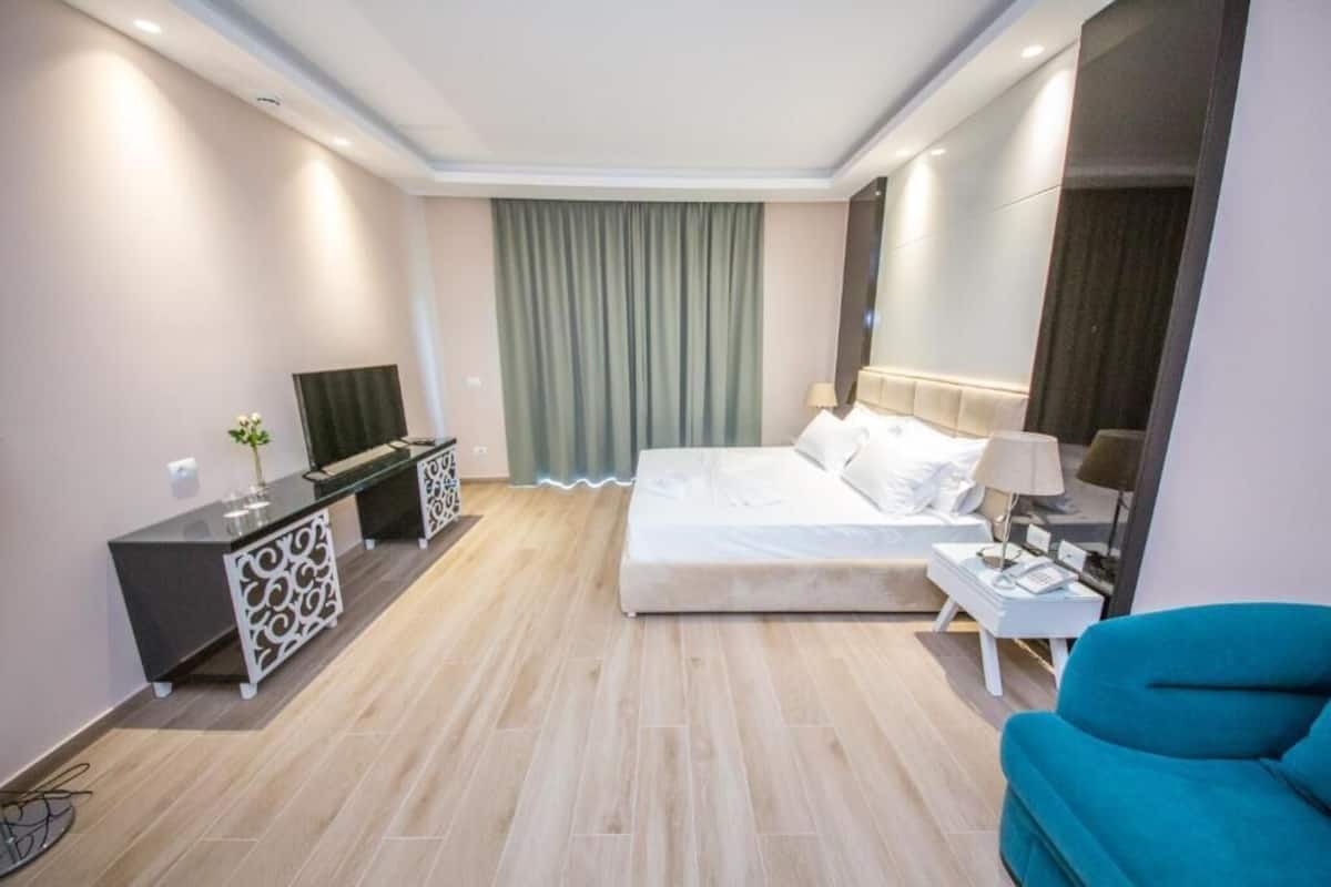Habitación triple Deluxe, balcón, planta baja | 1 habitación, minibar, caja de seguridad en la habitación y escritorio