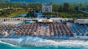 Playa privada, arena blanca, sillas reclinables de playa, sombrillas