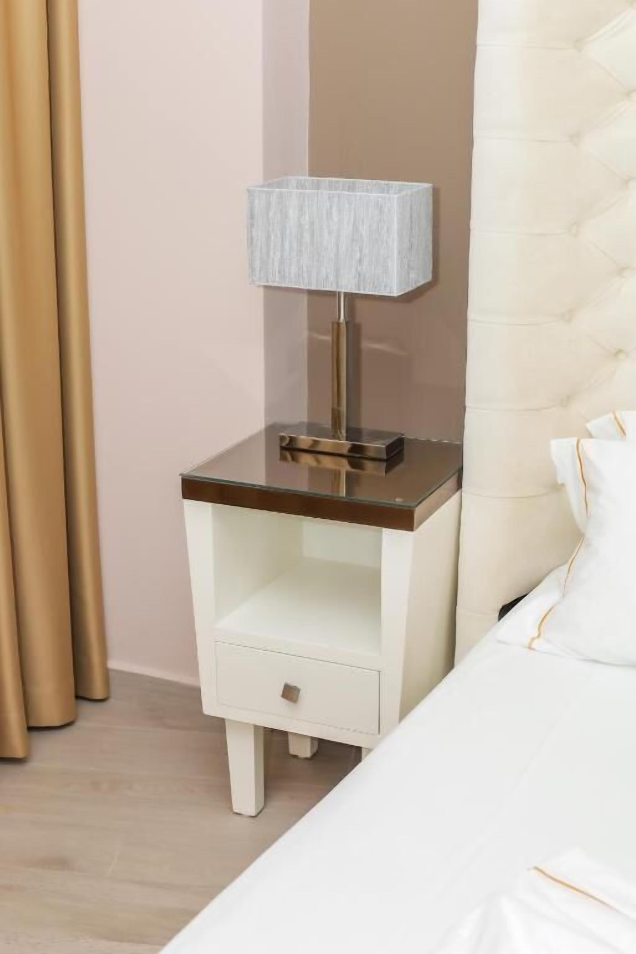 A neatly made bed with a white comforter and a tufted headboard.