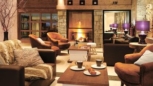 A cozy lounge area with leather sofas, a coffee table, and a fireplace. - 300m from resort center, fitness, swimming pool, sauna, hammam, terrace, balcony, tv, ski locker (Les Gets)