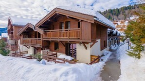 A wooden chalet with a balcony, surrounded by snow. - 300m from resort center, fitness, swimming pool, sauna, hammam, terrace, balcony, tv, ski locker (Les Gets)