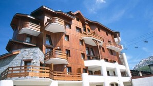 A multi-story building with wooden balconies and a stone facade.