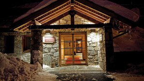 Un bâtiment en pierre, avec un toit en bois et une enseigne indiquant « Les Airelles ».