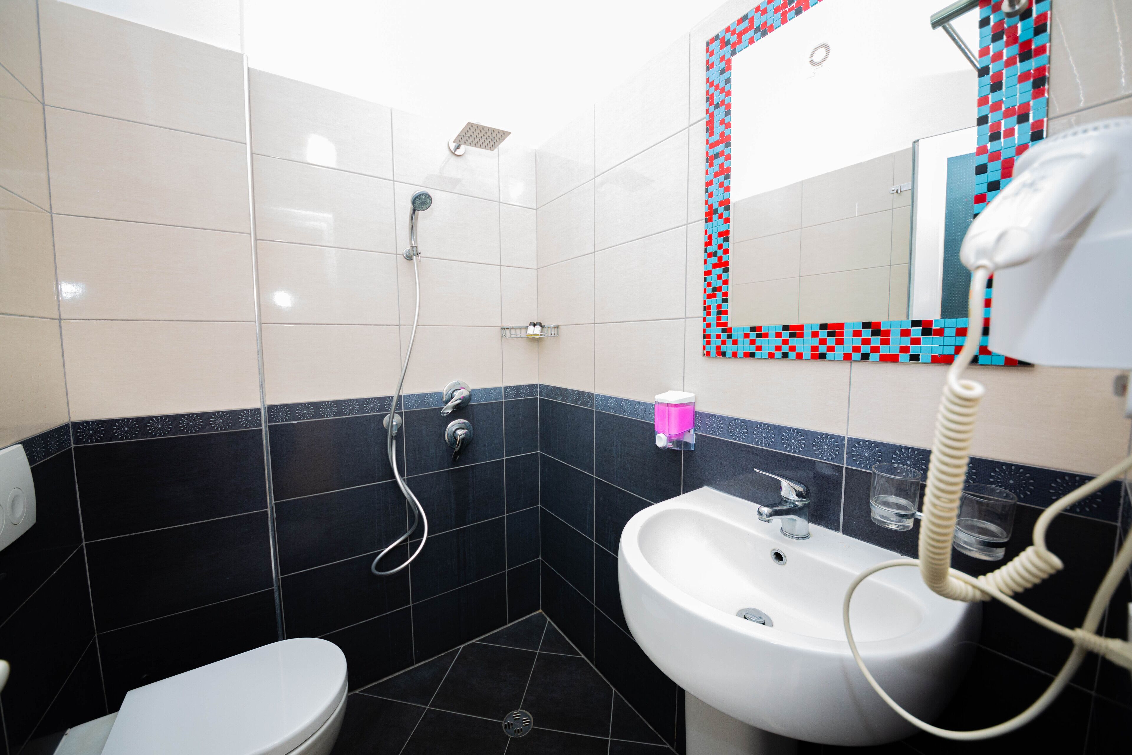 A bathroom with a toilet, sink, and shower.