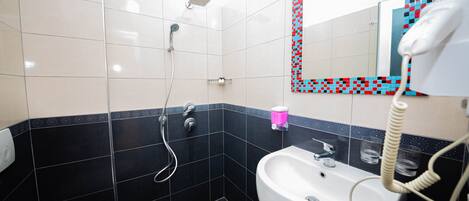 A bathroom with a toilet, sink, and shower.