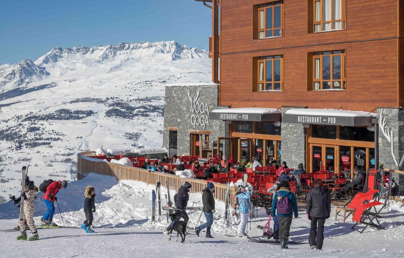 A restaurant with outdoor seating overlooking a snowy mountain landscape.