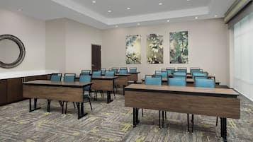 A conference room with multiple tables and chairs, a large mirror, and abstract wall art.