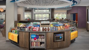 Een automaat met diverse keuze aan eten en drinken, waaronder gekoelde producten en een koffieapparaat.