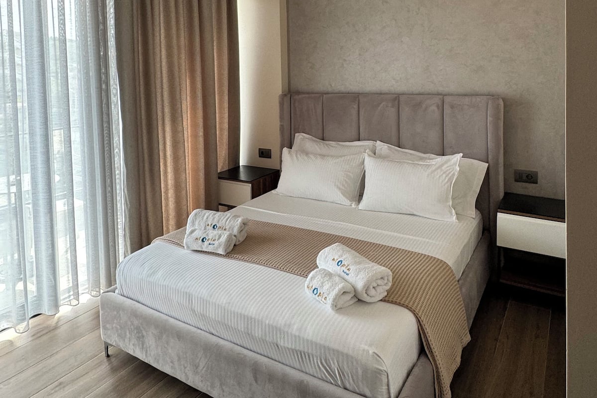 Habitación Deluxe doble, balcón, vistas parciales al mar | Minibar, caja fuerte, escritorio y cortinas opacas