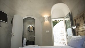 Ein Schlafzimmer mit Bett, Spiegel, Waschbecken und Fernseher.