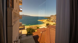 A view from a window overlooking a beach with buildings and a clear sky. - Hotel Apollon Saranda (Sarandë)