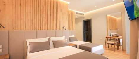 Una habitación de hotel moderna con una cama grande, un escritorio y un televisor.