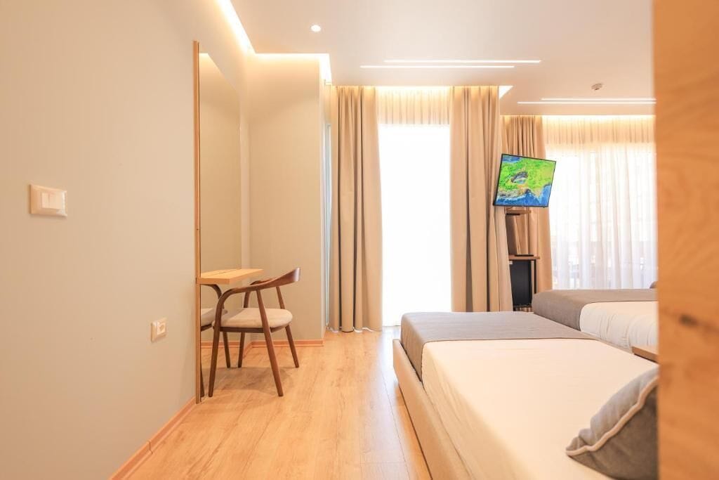 Une chambre d’hôtel équipée d’un lit, d’un bureau, d’une chaise et d’un téléviseur.