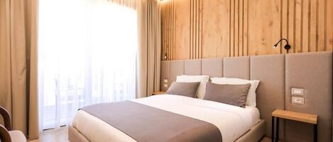 Camera da letto moderna con un letto grande, pareti rivestite in legno e un comodino.