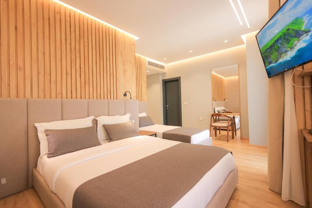 Una habitación de hotel moderna con una cama grande, un escritorio y un televisor.